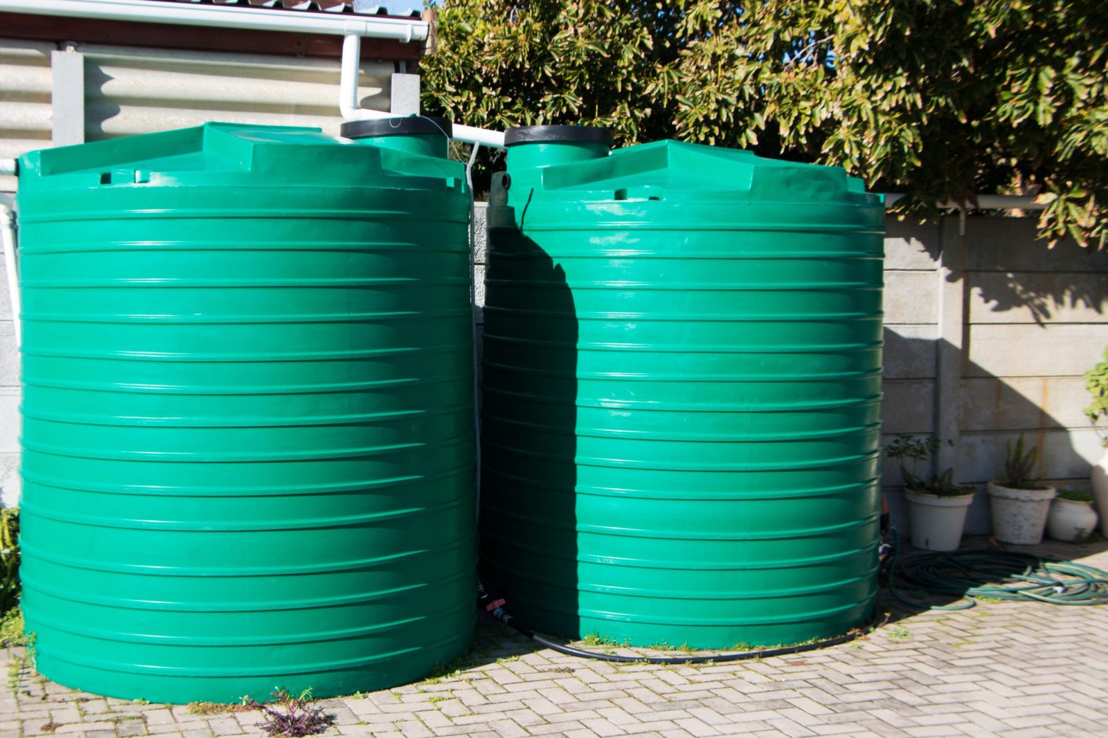 Unterirdische Regenwasserzisterne mit Deckel im Garten eines Einfamilienhauses